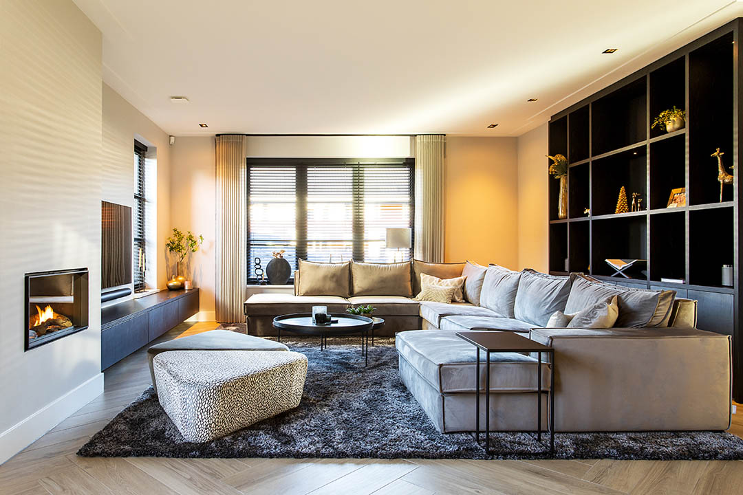 Ruime woonkamer met luxe grijze bank en ingebouwde wandkast - interieur ontwerpbureau - Studio Excellent
